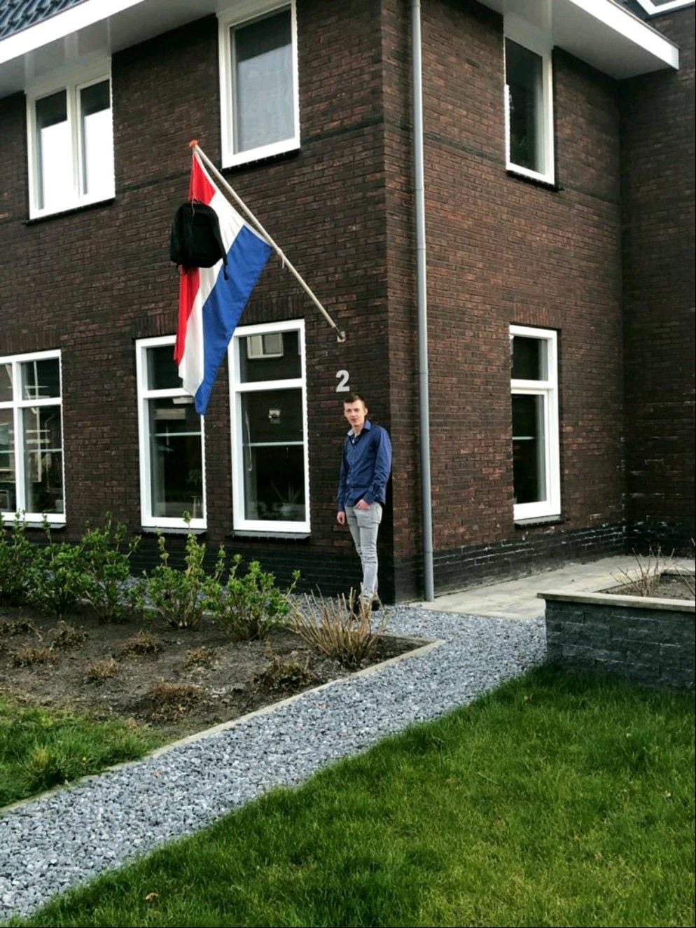 Jelmer met de vlag uit vanwege zijn behaalde diploma